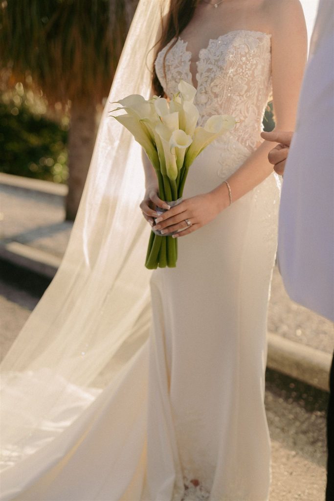 Bride holding a bouquet of lilies.